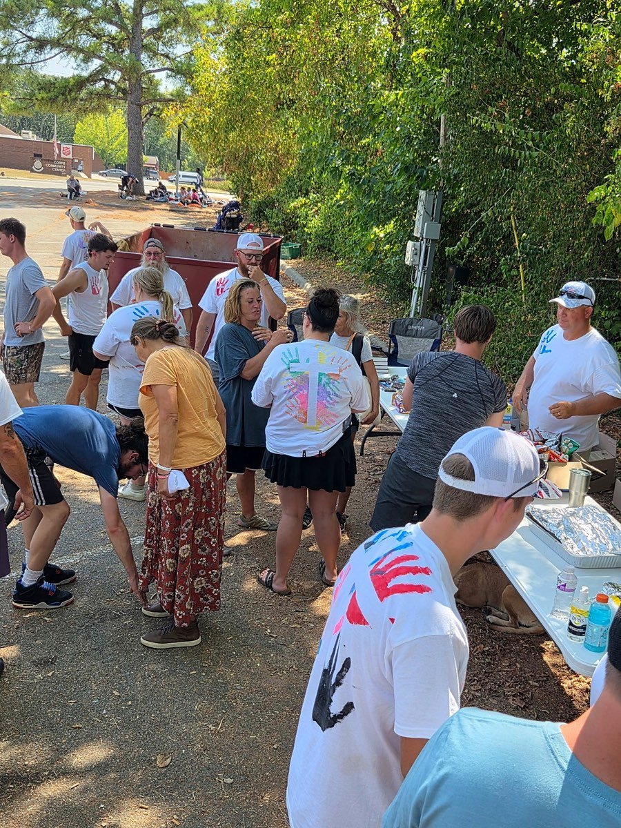 A crowd of volunteers and community members mingling at the outreach tables