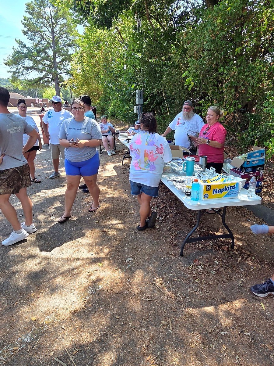 Community members lining up at a table of food and supplies